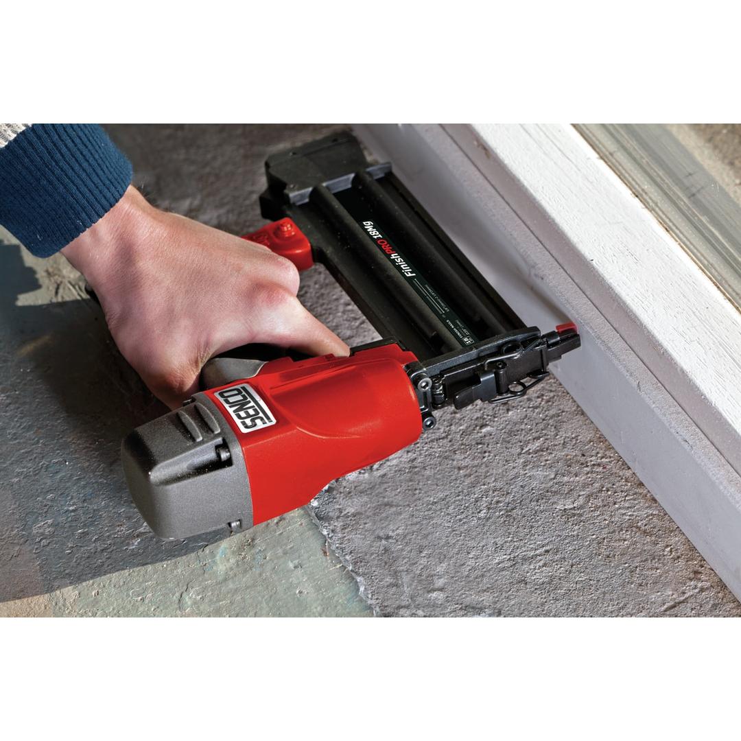 Cloueur pneumatique à brads 18 G en magnésium, 16 à 50 mm FinishPro18Mg SENCO - Cloueur de finition SENCO FinishPro18 Mg en main contre un encadrement de porte blanc sur chantier