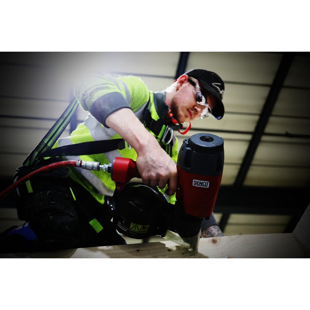 Cloueur à rouleau pneumatique, 45 à 90 mm CoilPro90 SENCO - Cloueur à rouleau SENCO CoilPro90 45-90 mm utilisé par un ouvrier en gilet jaune sur une poutre bois