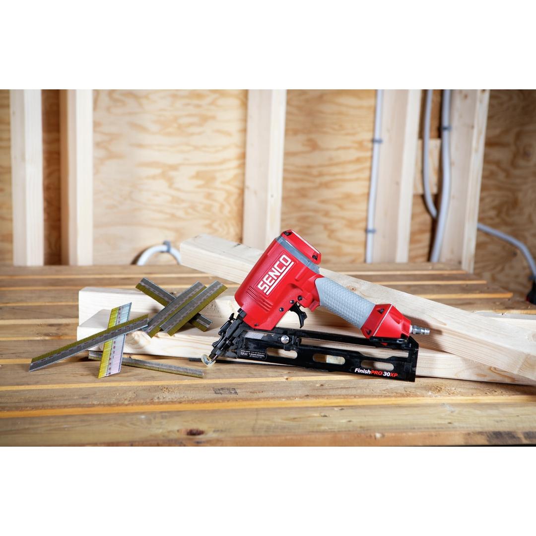 Cloueur pneumatique FINISHPRO 30XP DUAL/RESTR SENCO — Cloueur SENCO FinishPro 30XP 25-50 mm posé sur des planches en atelier, deux bandes de clous à côté