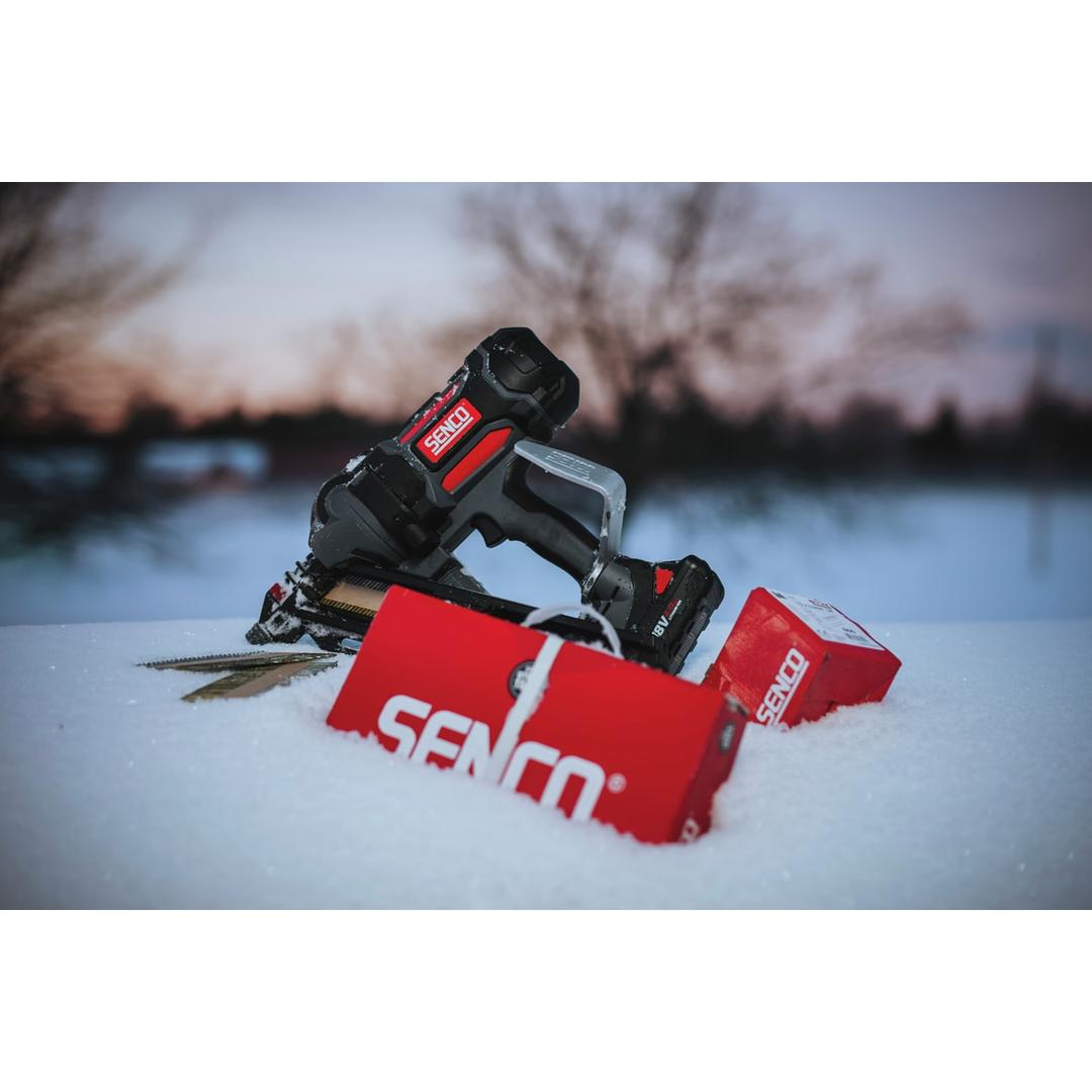 Cloueur sur batterie FUSION F-35XP + 2 batteries 4Ah SENCO — Cloueur SENCO Fusion F-35XP 50-90 mm posé dans la neige au crépuscule, boîtes de clous à côté