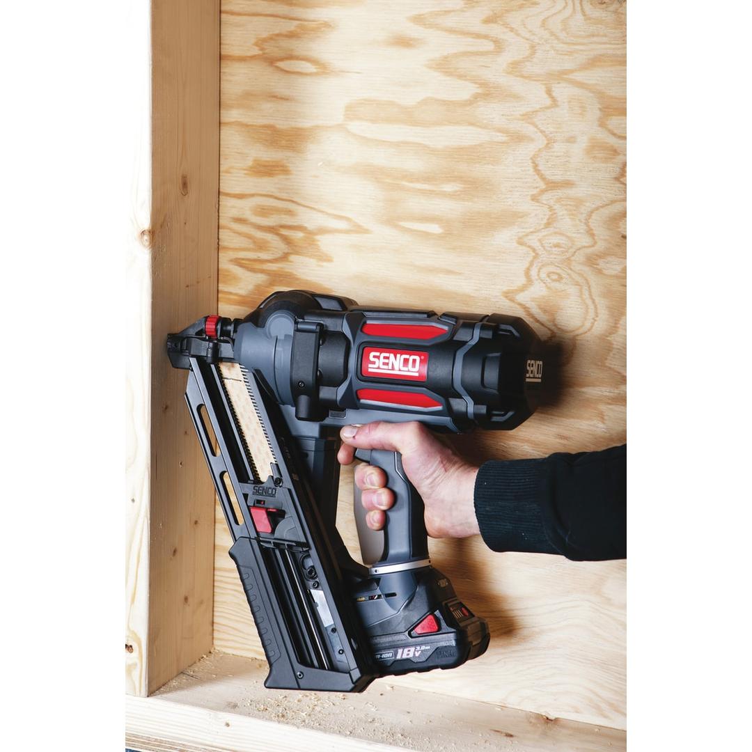 Cloueur sur batterie FUSION F-35XP + 2 batteries 4Ah SENCO — Cloueur SENCO Fusion F-35XP 50-90 mm tenu contre un mur en contreplaqué, magasin chargé de clous