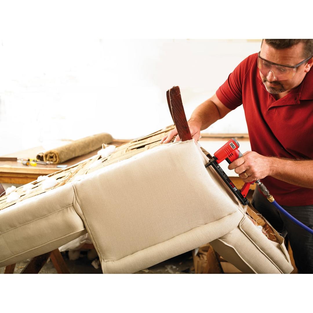 Agrafeuse pneumatique SFW09 AT SENCO — Agrafeuse SENCO SFW09 AT 6-16 mm en main pour agrafer une toile beige sur un fauteuil en réfection