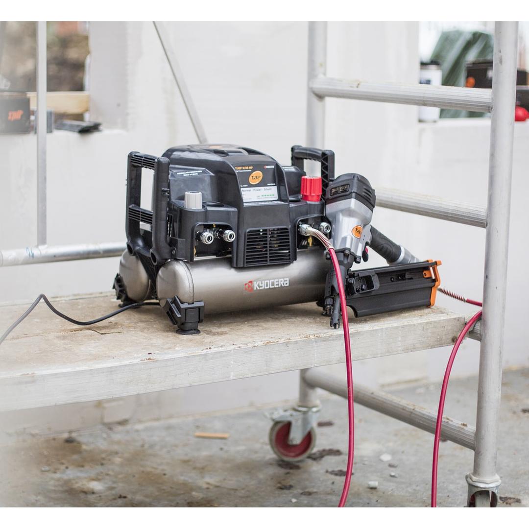 Compresseur HAUTE PRESSION 9/20 2x4,5l - 42 bar TJEP — Compresseur TJEP 9/20 HP en service sur un plateau d'échafaudage, un cloueur à rouleau TJEP raccordé posé à côté et deux flexibles rouges partant vers le chantier