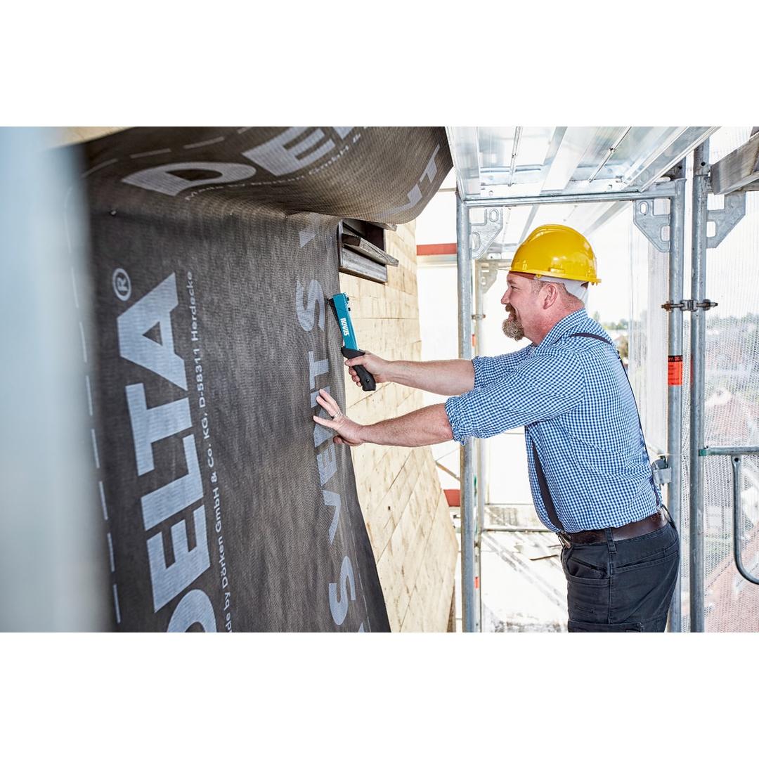 Marteau agrafeur manuel Marteau agrafeur J-044 NOVUS — NOVUS marteau agrafeur J-044 — agrafage d'une membrane DELTA sur façade bois, vu depuis l'échafaudage