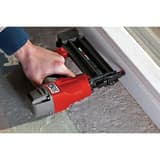 Cloueur pneumatique à brads 18 G en magnésium, 16 à 50 mm FinishPro18Mg SENCO - Cloueur de finition SENCO FinishPro18 Mg en main contre un encadrement de porte blanc sur chantier