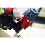 Cloueur à rouleau pneumatique, 45 à 90 mm CoilPro90 SENCO - Cloueur à rouleau SENCO CoilPro90 en main, clouage sur un panneau clair en gros plan