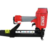 Agrafeuse à couronne large pneumatique PS20XP SENCO — Agrafeuse SENCO PS20XP de profil magasin à gauche, étiquette CE et triangle jaune d'avertissement