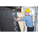 Marteau agrafeur manuel Marteau agrafeurJ-033 NOVUS — NOVUS marteau agrafeur J-033 — fixation d'un pare-pluie noir sur une façade bois depuis l'échafaudage